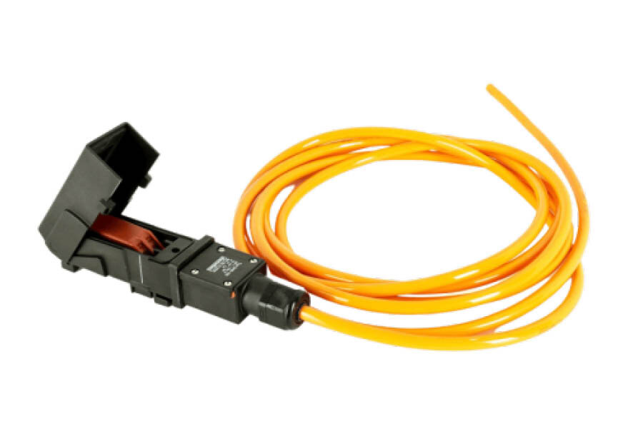 A black connection system for heating tapes, featuring an open housing and visible copper contacts. A bright orange cable is connected to it and coiled into a loop against a plain background.